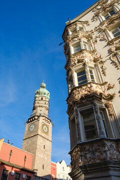 Low angle view of Stadtturm and Helbling House against blue sky at Innsbruck, Austria
