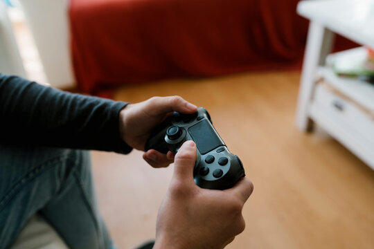Man with game controller playing video game at home