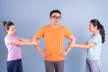 Three young Asian people posing on blue background