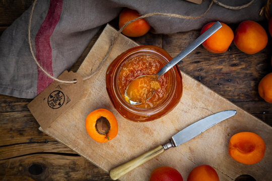 Apricot jam and apricots on dark wood