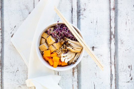 Miso Ramen soup with noodles, hokaido pumpkin, red radish sprouts, fried tofu, shimeji mushroom and king trumpet mushroom
