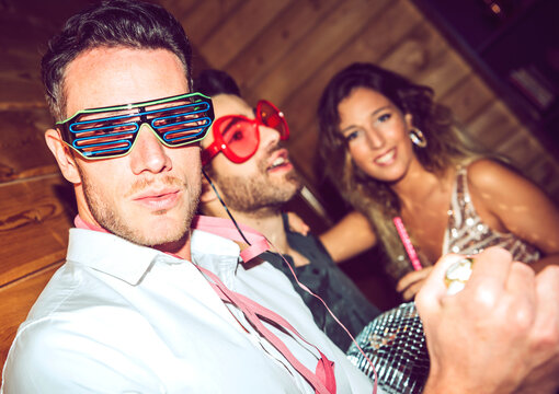 Young man wearing shutter shade while enjoying with friends in party