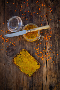 Jar of homemade red lentil paste and slice of wholegrain bread