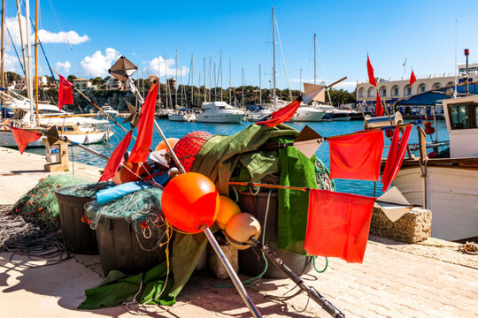 Spain, Mallorca, Porto Cristo, Buoys, flags and fishing nets lying in harbor