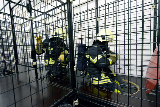 Two firefighters with respirator and air tank exercising