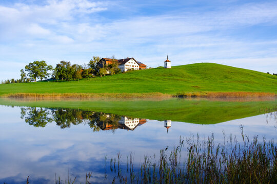 Germany, Bavaria, Halblech, Chapel and farmhouse reflecting in&Ocirc;&oslash;&Omega;Hegratsrieder&Ocirc;&oslash;&Omega;See lake