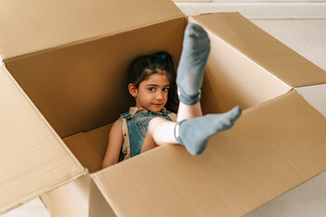 Portrait of little girl inside a cardboard box