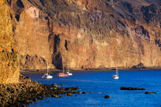 Spain, La Gomera, Valle Gran Rey, Sailboats moored in front of coastal cliff