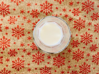 Milk in a glass close-up top view. Christmas drink. christmas background with snowflakes.