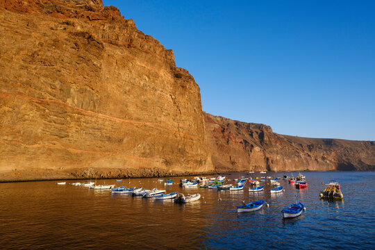 Spain, La Gomera, Valle Gran Rey, Boats moored in front of coastal cliff