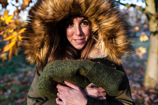 Woman in fur coat holding blanket standing at Hyde Park during autumn
