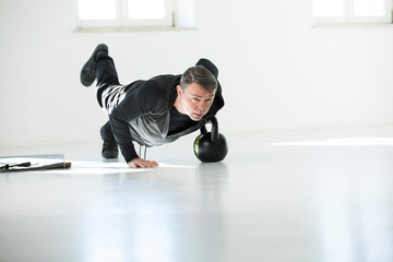 Man doing his fitness regime, doing kettle bell push-ups