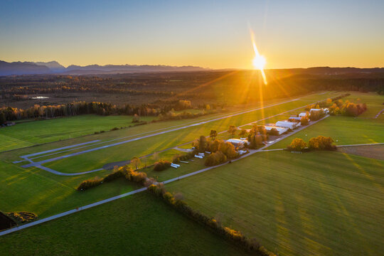 Germany, Bavaria, Upper Bavaria, Toelzer Land, Konigsdorf, Aerial view of fields and village at sunset
