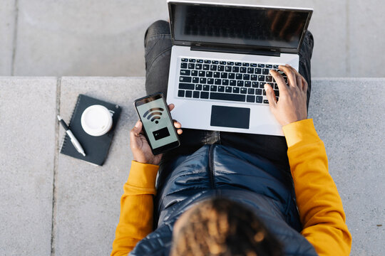 Top view of man using laptop and smartphone for online shopping