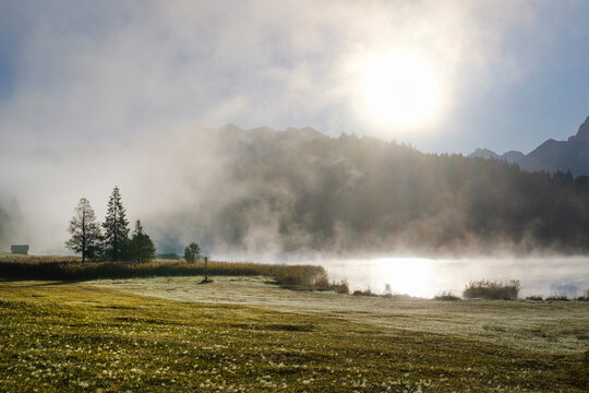 Germany, Bavaria, Krun, Wafts of fog floating over shore of Geroldsee at sunrise