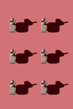 Pattern of small brown donkey figurines against pastel red background
