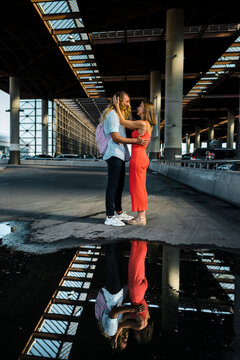 Couple standing face to face by reflection on puddle in city