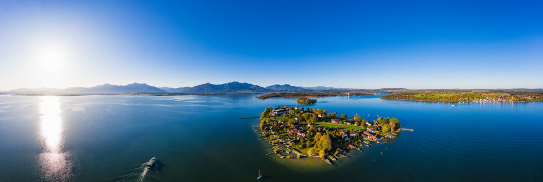 Germany, Bavaria, Aerial panorama of sun shining over Frauenchiemsee islet