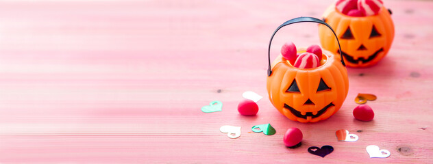 happy Halloween. pumpkins, candies and hearts on pink background