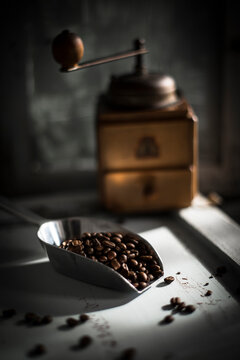 Scoop of roasted coffee beans&Ocirc;&oslash;&Omega;with coffee grinder in background