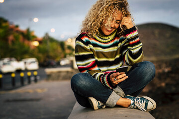 Portrait of woman wearing colorful pullover and using smartphone, Tenerife, Spain