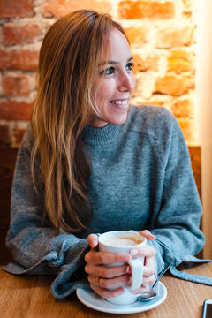 Smiling woman holding coffee cup at coffee shop