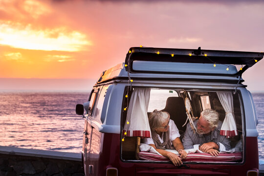 Senior couple traveling in a vintage van, lying in boot