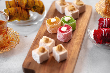 Various Turkish sweets and cup of tea on white textured background