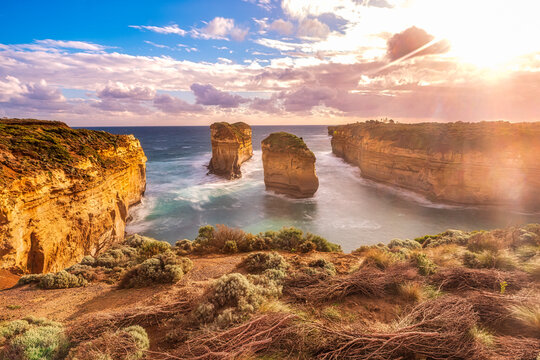 Stack rocks in sea at Loch Ard Gorge against sky during sunny day, Victoria, Australia