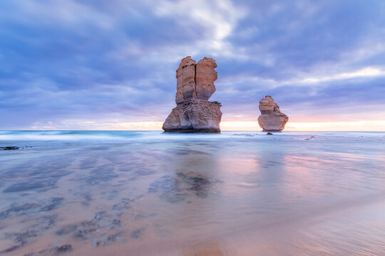 Stack rocks in sea at Gibson Steps against cloudy sky during sunset, Victoria, Australia