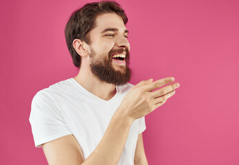 emotional man in a white t-shirt happy facial expression pink background
