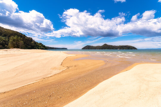 Scenic view of beach against sky during sunny day at Abel Tasman Coastal Track, South Island, New Zealand