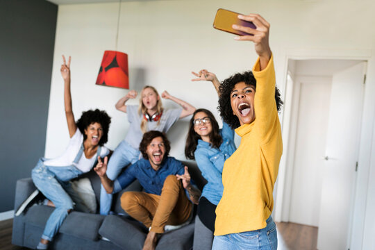Cheerful friends taking a selfie at home