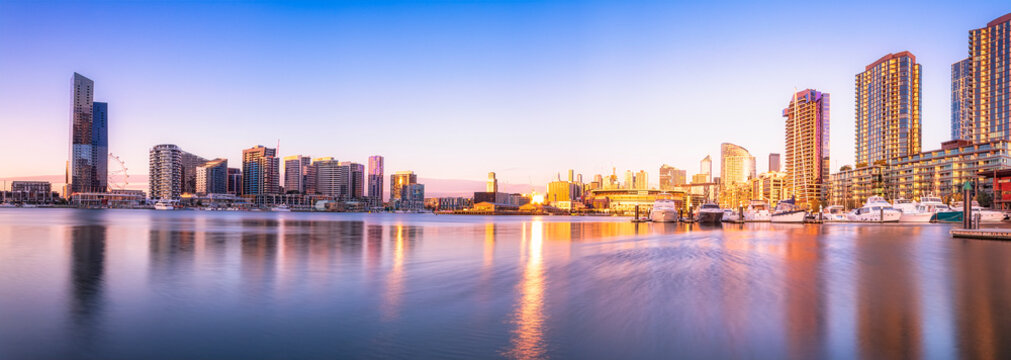 Modern buildings in front of Yarra River at Melbourne Docklands against sky at sunset, Victoria, Australia