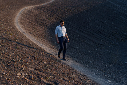 Mature businessman walking on a disused mine tip