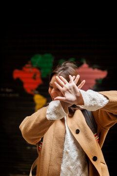 Happy young woman covering her face with her hands