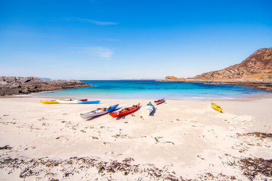 Multi colored kayaks at Smirisary beach against sky, Lochaber, Scotland, UK