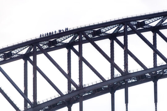 Fototapeta Silhouette people climbing Sydney Bridge against clear sky, Australia