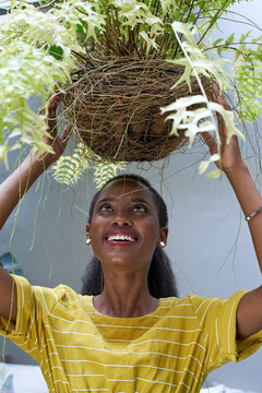 Happy young woman holding a plant