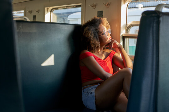 Young woman on a train looking out of window