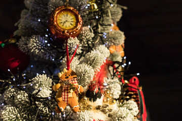 Close up of holidays location with soft toy and garlands on red white Christmas tree