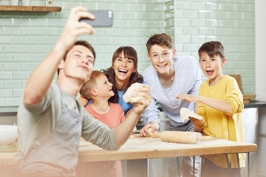 Sone taking pictures of his mother and brothers, preparing pizza at home