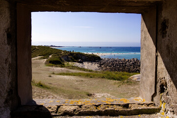 Vue sur la mer à Cléder dans le finistère par le troud e fenêtre d'une ancienne réserve d'armes.