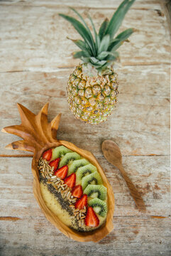 Smoothie Bowl with mango and pineapple garnished with kiwi, strawberries, chia and sunflower seed