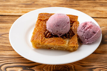 Turkish dessert kunefe served with ice cream on wooden background