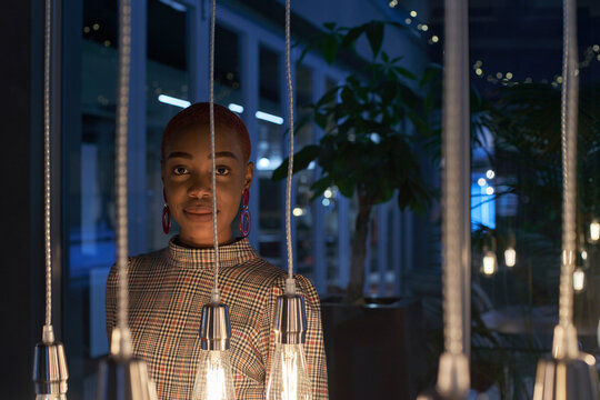 Young woman with short hair behind the lights