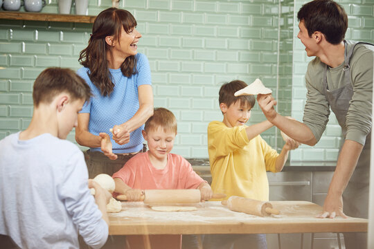 Mother and sons preparing pizza at home