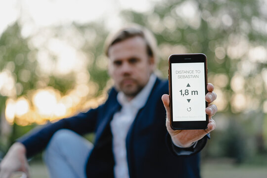 Close-up of businessman holding smartphone showing distance on display - Powered by Adobe