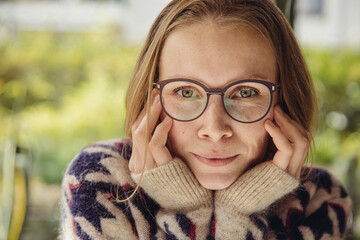 Portrait of young woman with glasses wearing fluffy sweater