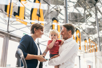 Happy family with business mother at the airport